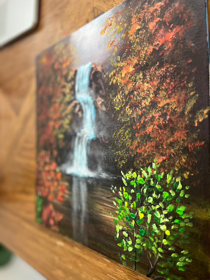 Vibrant waterfall painting on a black canvas